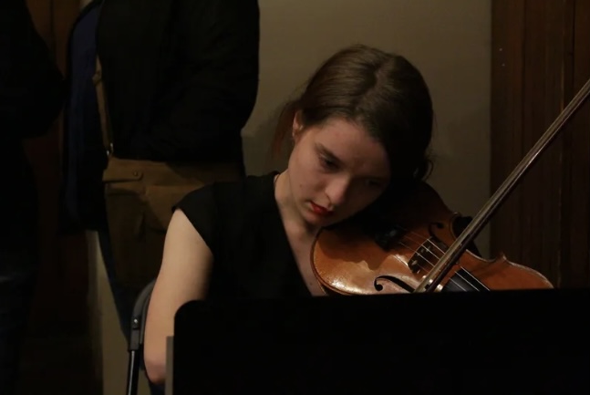 Photo of Adeline Kovell playing the violin.