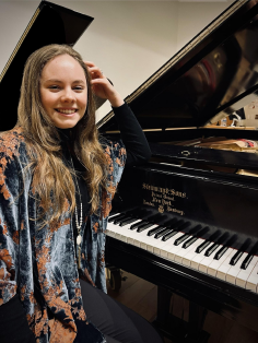 Photo of Savannah Baber in front of a piano.